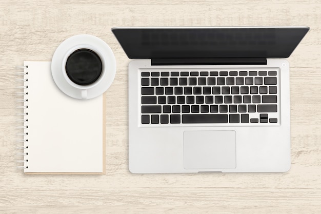 Laptop computer and blank notebook on wood. Top view business background.