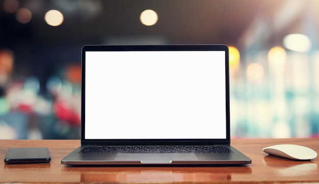 Laptop computer blank white screen and mobile on table in cafe background