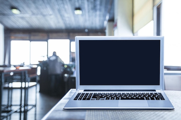 Laptop computer displaying blank screen on the desk