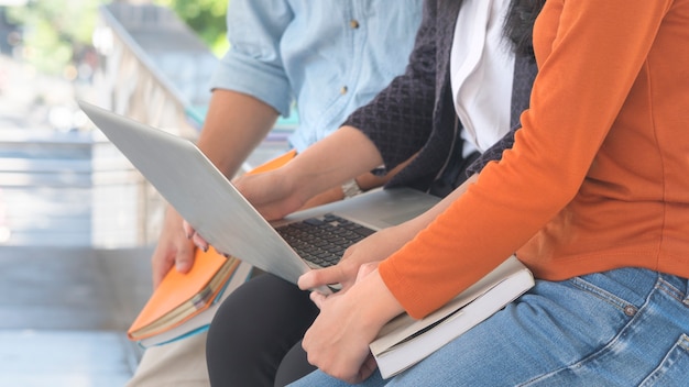 laptop computer and group of three people while pointing on screen monitor.