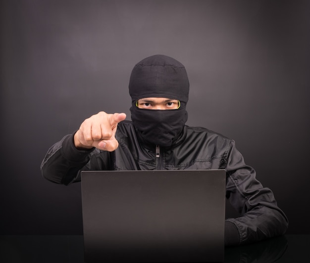 노트북 컴퓨터 해커 포인트 손-블랙에 노트북 컴퓨터에서 데이터를 훔치는 남성 도둑