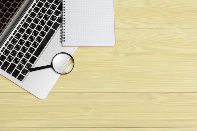 Laptop computer keyboard with magnifying glass,  of search