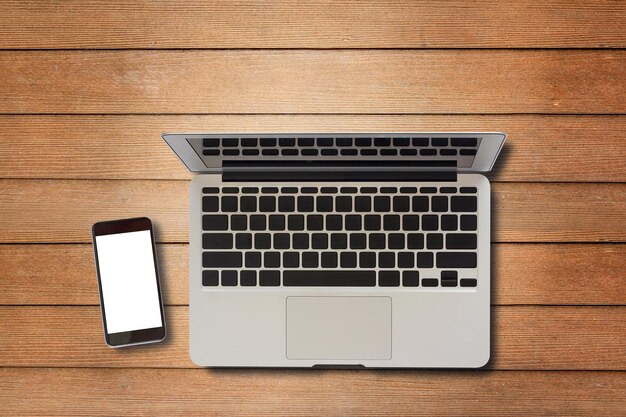 Laptop computer and smart phone on wood table