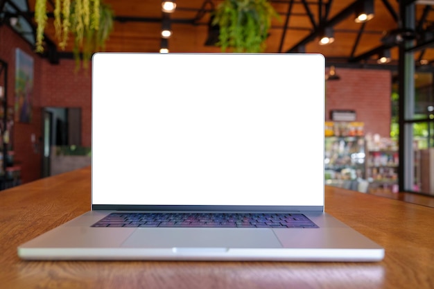Ноутбук с пустым экраном на столе в кафеНоутбук с пустым экраном на столе в кафе размытие фона