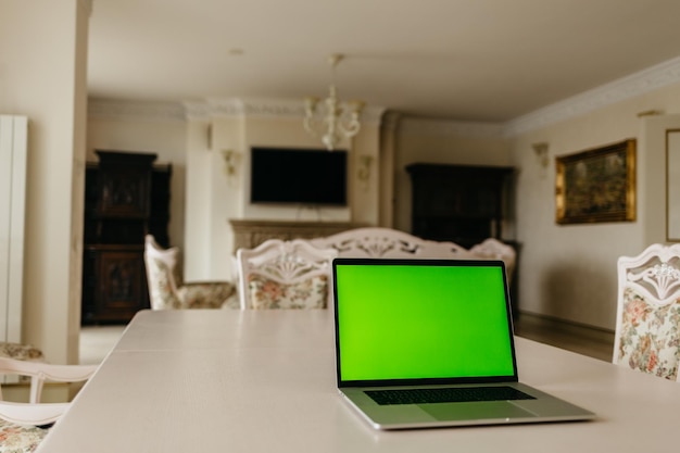 Photo laptop computer with green screen in room