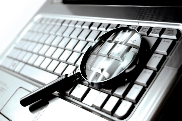 Photo laptop computer with magnifying glass concept of search