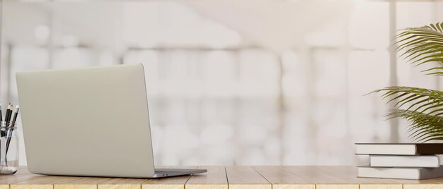 Laptop computer on wooden tabletop with copy space over blurred office background 3d render