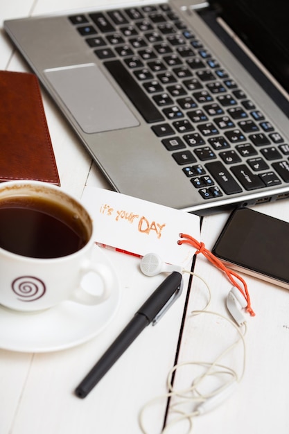 Laptop and a cup of coffee, headphones, notebook, phone