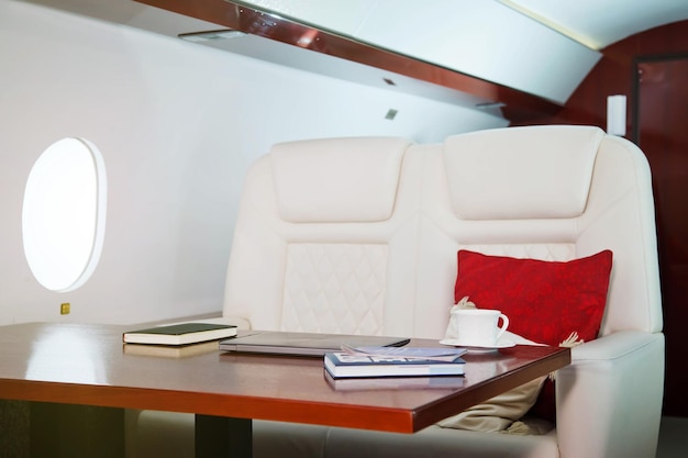 Laptop dagboek en kopje koffie op tafel van luxe interieur in privéjet