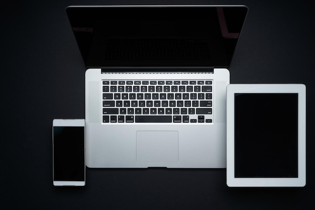 Photo laptop, digital pad and smartphone on black background,top view