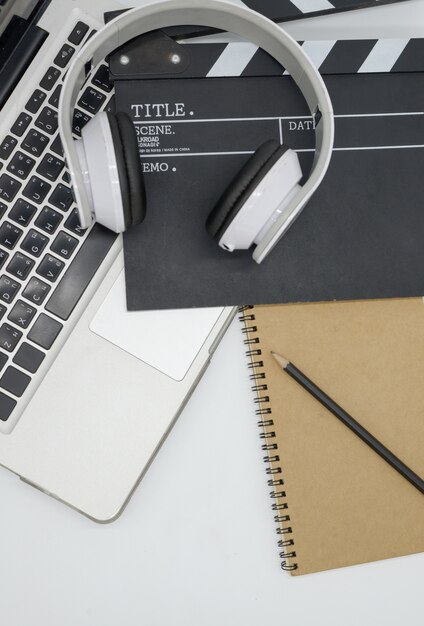 laptop, earphone, Movie clapper board, note pad on white background