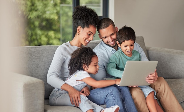 L'elearning sul laptop e la famiglia sul divano o i genitori aiutano con il supporto all'istruzione dei bambini o guardano insieme lo spettacolo di cartoni animati rilassati madre, padre e bambini sul divano su divertenti giochi per pc digitali o streaming online