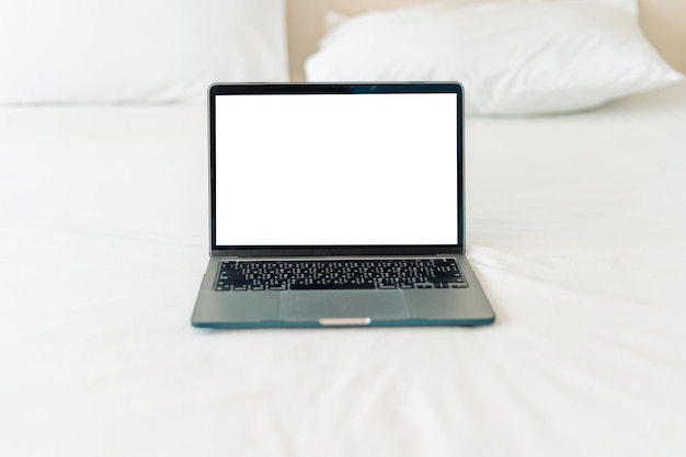 Laptop on empty bedCaucasian woman laying on bed using laptop