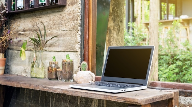 Laptop en cactus in de buurt van een raam