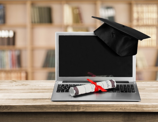 Laptop en diploma scroll op achtergrond