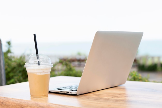 Foto laptop en drankje op tafel buitenshuis