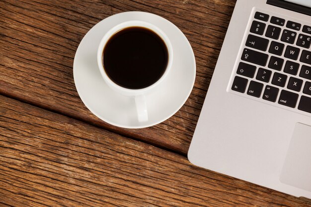 Laptop en kopje koffie op houten tafel