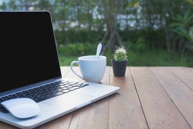 laptop en kopje koffie op houten tafel.