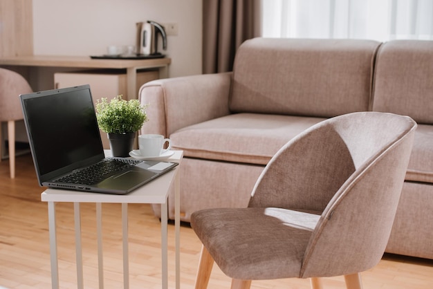 Laptop en kopje koffie op tafel op sofa achtergrond in hotelkamer Workplace concept