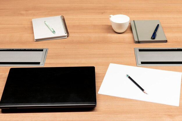 Laptop en notebook op tafel in vergaderruimte