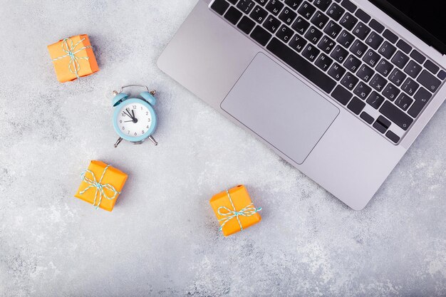 Laptop en oranje presenteert op blauwe tafel plat vakantie online winkelconcept foto van hoge kwaliteit