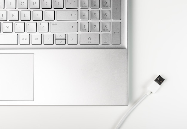 Laptop en witte usb-kabel op bureau