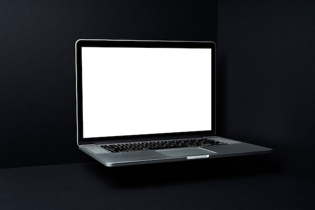 Computer portatile galleggiante con schermo bianco vuoto su sfondo nero tridimensionale mockup