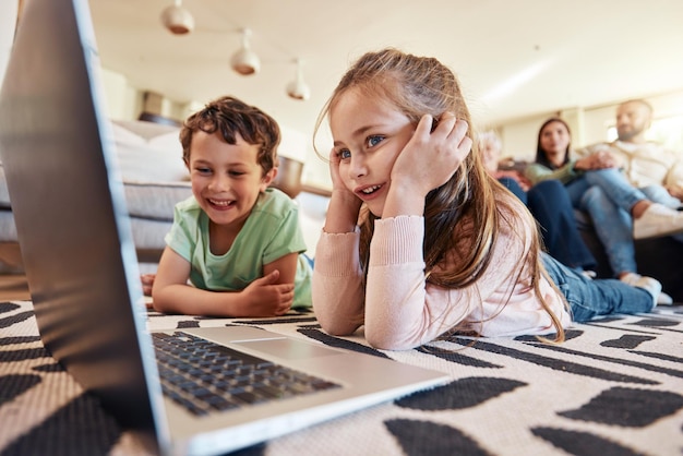 Laptop floor or children with parents relaxing on sofa for online education cartoon video subscription or watch movies Happy kids on carpet computer or streaming film together with family at home