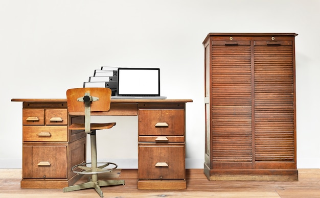 Laptop and folder lying on a vintage desk