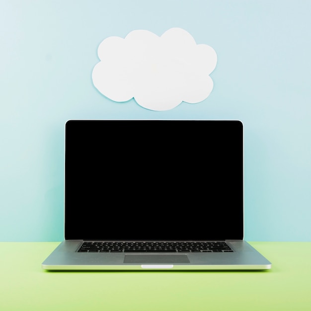 Laptop in front of wall with cloud paper