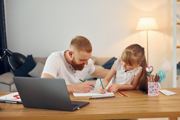 Laptop gebruiken Vader met zijn dochtertje is samen thuis