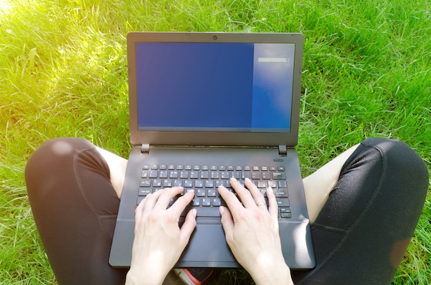 푸른 잔디에 여자 무릎에 노트북