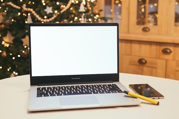 크리스마스 트리 따뜻한 빛이 있는 집에 있는 노트북 원격 작업 프리랜서 재택 근무