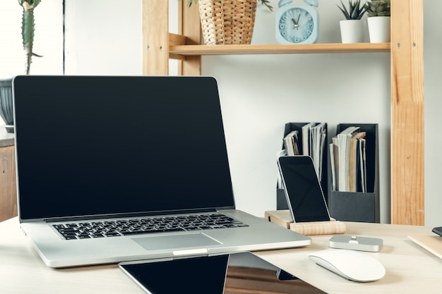 Laptop in een lichte kamer op werktafel met kantoorbenodigdheden