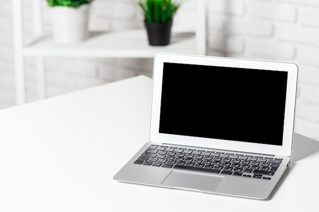Laptop in verlichte witte kamer, thuis of op kantoor interieur