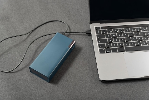 Laptop is via snoer aangesloten op een externe accu werkplek met laptop wordt opgeladen via powerbank