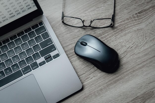 写真 ノートパソコンのキーボードマウスメガネテーブルの上での作業囲気フリーランスのビジネス