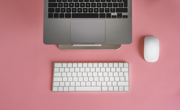 Laptop keyboard from above Clean empty peach colour background