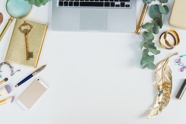 Tastiera per laptop con accessori donna dorati e piante verdi simulano una scena in stile piatto