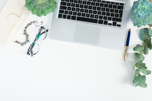 Laptop keyboard with green plants mock up flat lay styled scene with succulents plant, top view, copy space on white desktop