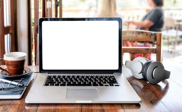 Laptop met het lege witte scherm op houten lijst in koffiewinkel.