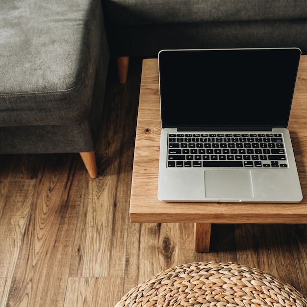 Laptop met leeg mockup-scherm op massief houten tafel.