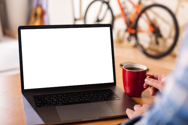 Laptop met leeg wit scherm en mannelijke handen op het toetsenbord