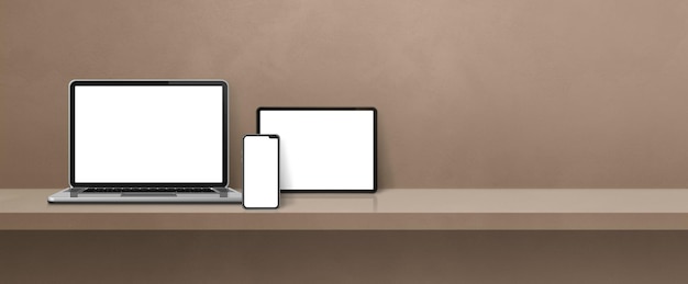 Laptop mobile phone and digital tablet pc on brown wall shelf Banner background