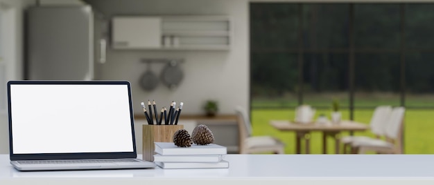 Mockup per laptop e spazio per la copia sul tavolo bianco sopra la cucina sfocata in primo piano sullo sfondo