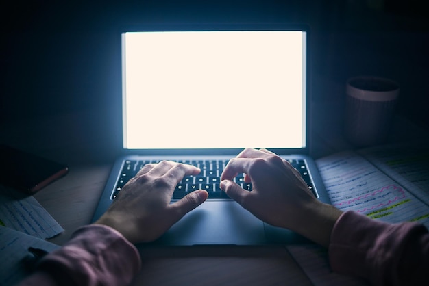 Laptop mockup and hands on keyboard at dark table for studying seo research or elearning technology Student perspective desk and typing on blank computer screen internet project and night course