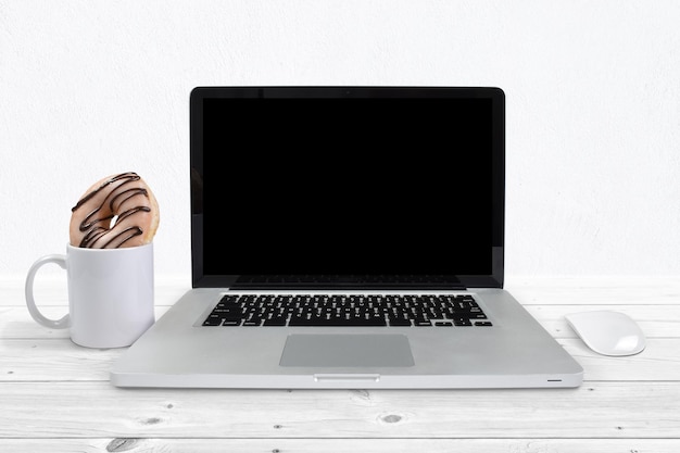 Фото Макет ноутбука с кружкой кофе и пончиком