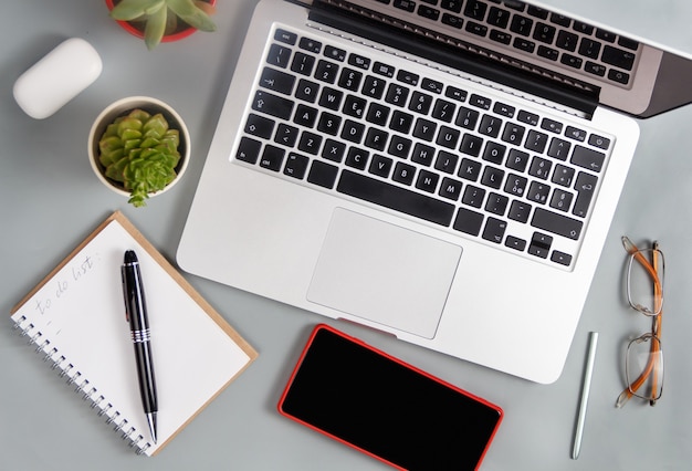 Laptop and modern gadgets on a grey office desk top view. Business concept