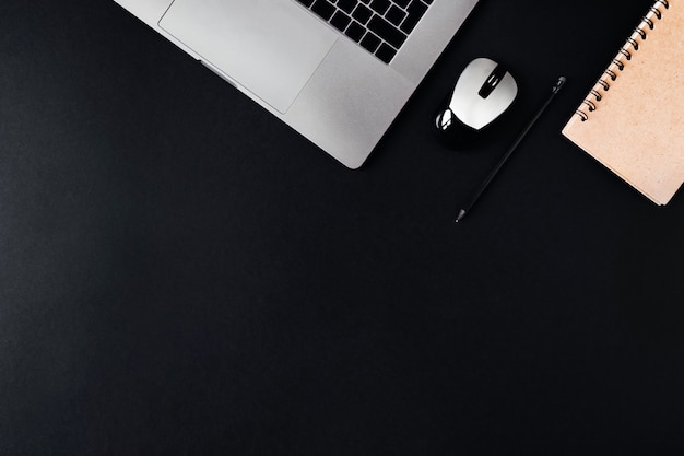 Photo laptop, mouse and notepad on a black background