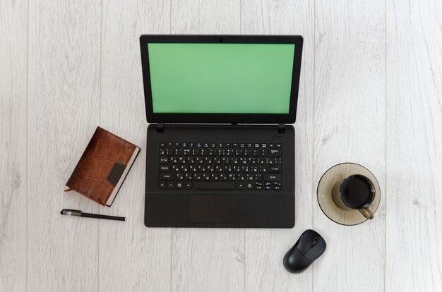 Photo laptop, mug of coffee and a notebook. top view